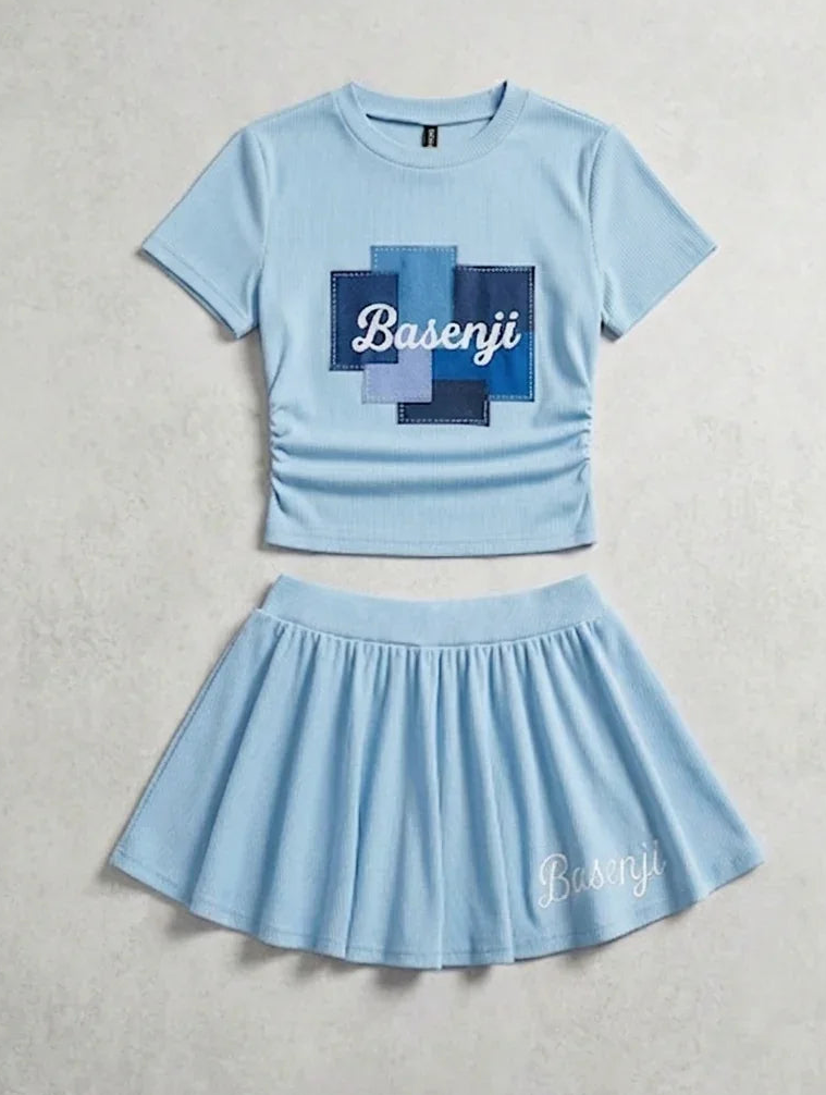 Silent Sky Set: light blue cropped ribbed top with patchwork cross and Basenji script, paired with a pleated mini skirt